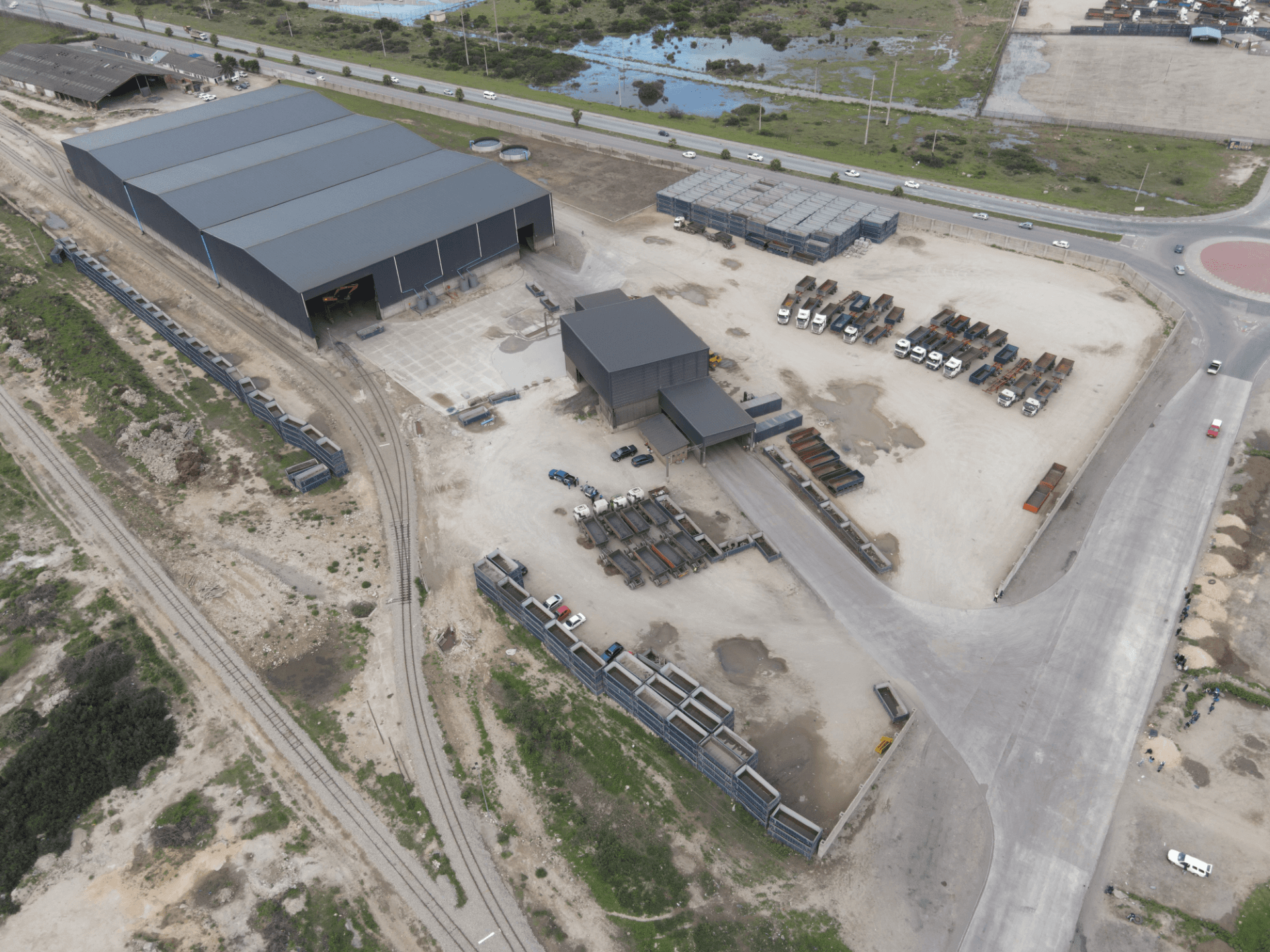 Aerial view of a large operational yard with warehouses and vehicles