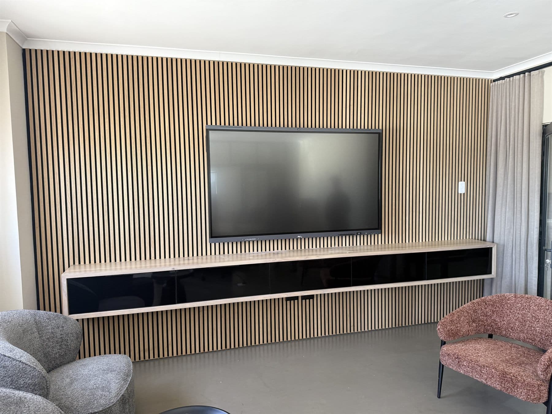 Installed media wall with display and timber slat finish